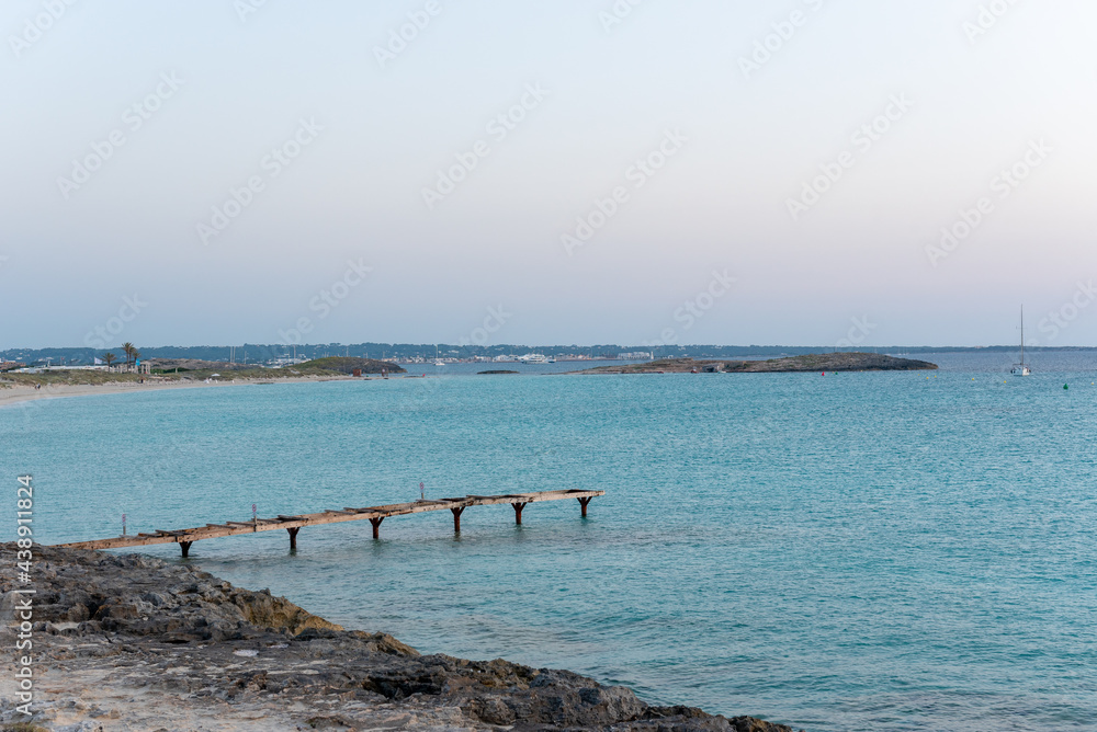 Pier in deserted beach of Ses Illetes on the Island of Formentera in Spain.