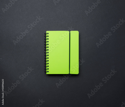 An open notebook on a black background top view, a school notebook on a dark table. Office desk flat layout, set of items.