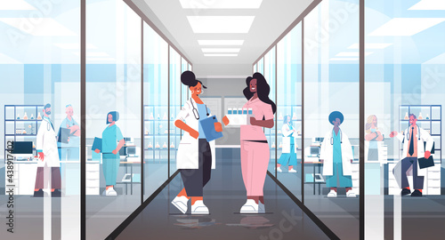 mix race doctors in uniform discussing during meeting in hospital corridor medicine healthcare concept
