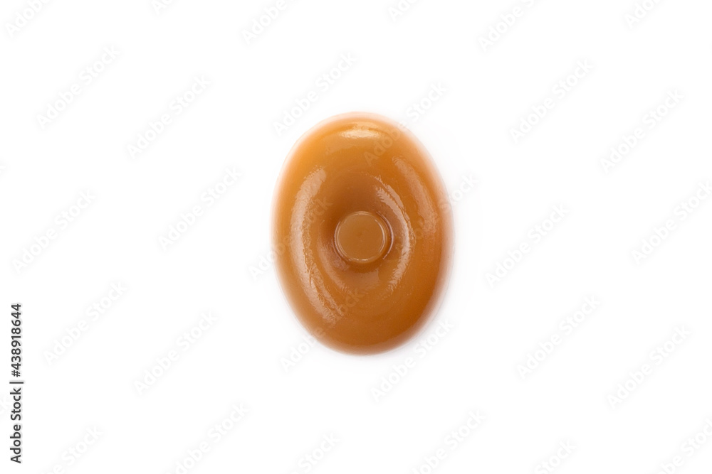 Three caramel candies on a white background close-up.