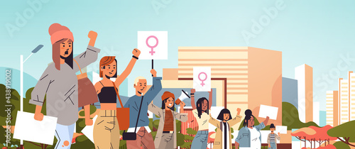 mix race activists holding placards with female gender sign feminist demonstration girl power movement rights protection women empowerment concept portrait cityscape background horizontal