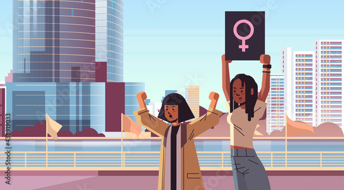 mix race activists couple holding blank placards feminist demonstration girl power movement rights protection women empowerment concept portrait cityscape background horizontal