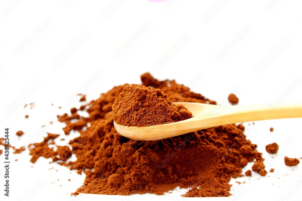 Spoon full of ground coffee, white background
