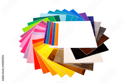 Twisted pile of colorful 12x12 sheets of adhesive paper isolated over the white background. photo