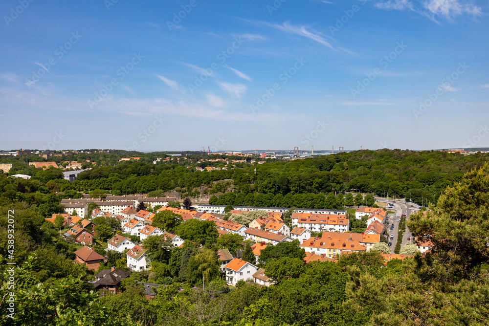 Elevated view of south part of city of Gothenburg in spring on a clear day. Residential buildings surrounded by lush tree landscape.