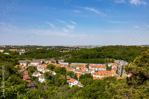 Elevated view of south part of city of Gothenburg in spring on a clear day. Residential buildings surrounded by lush tree landscape.