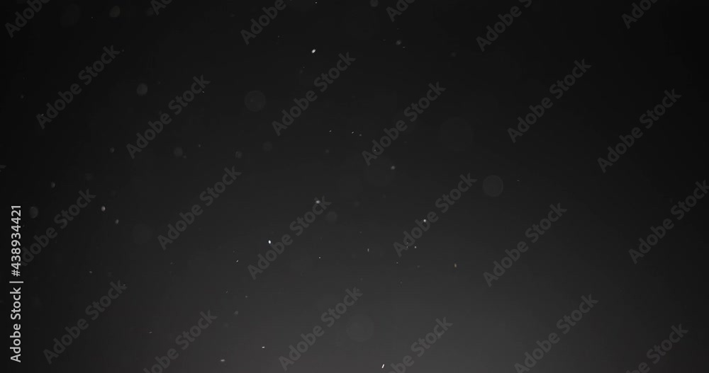 Fine particles flying around against dark background Fine particles flying around against dark background