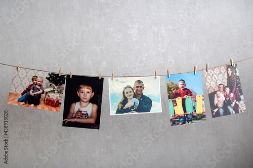 Family photo cards hang on rope. Memories. Home photo gallery, original photo exhibition. Best moments