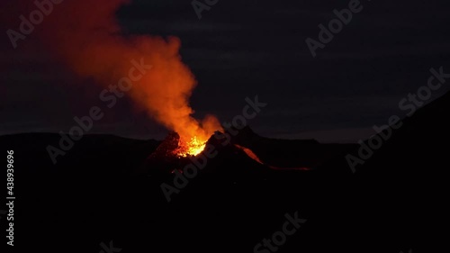 Glow in the darkness of erupting volcano, Iceland. Static view photo