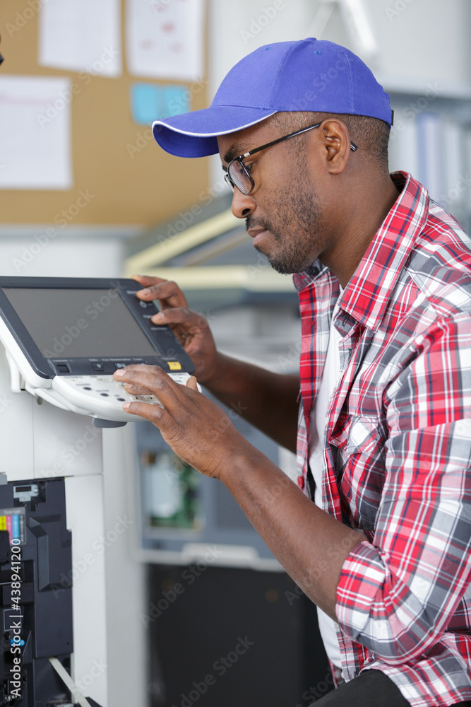 repair man checks printer at office repair man checks printer at office
