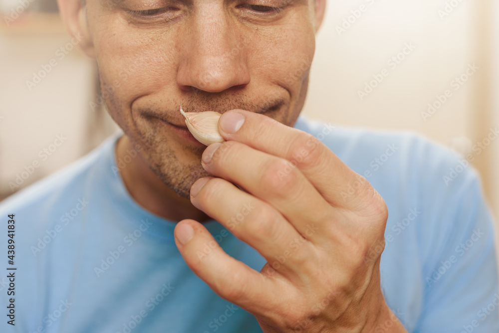 Fototapeta premium Man smelling garlic, this test result means he is healthy