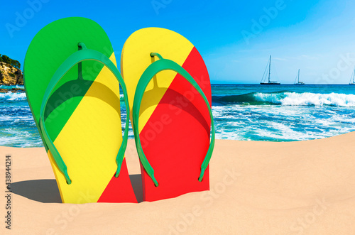 Flip flops with Congolese flag on the beach. Congo resorts  vacation  tours  travel packages concept. 3D rendering