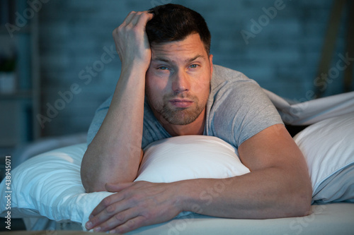 man with sleep problem in his bed at home