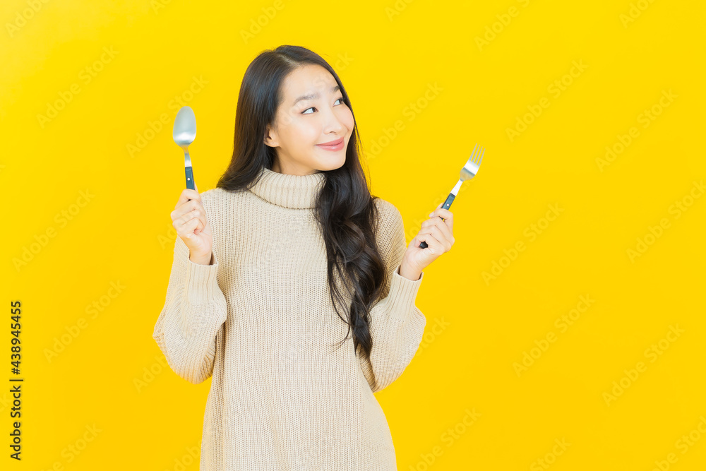 Portrait beautiful young asian woman smile with spoon and fork Portrait beautiful young asian woman smile with spoon and fork