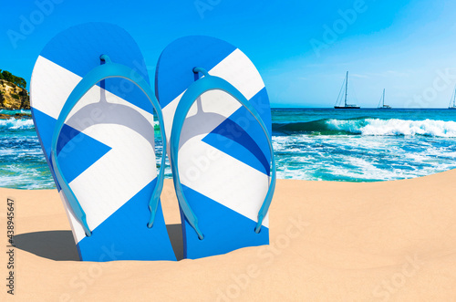 Flip flops with Scottish flag on the beach. Scotland resorts, vacation, tours, travel packages concept. 3D rendering