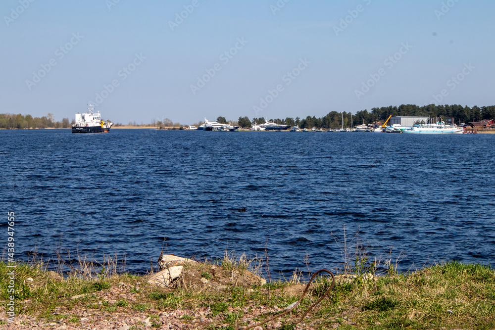 View of the water surface with light waves and pleasure yachts in the distance