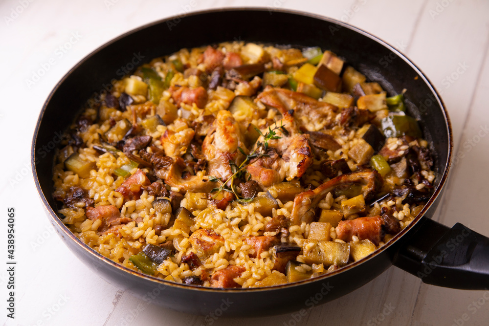 Spanish paella with rabbit, sausages, vegetables and artichokes. Traditional recipe from the Mediterranean area. Spanish paella with rabbit, sausages, vegetables and artichokes. Traditional recipe from the Mediterranean area.