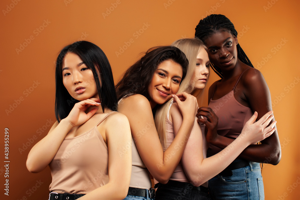 Obraz premium young pretty asian, caucasian, afro woman posing cheerful together on brown background, lifestyle diverse nationality people concept