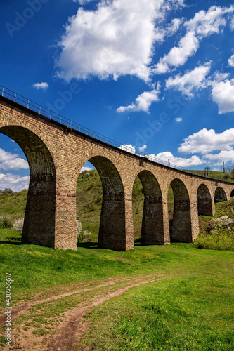 Old railway stone viaduct in the spring in sunny day. © Sergii