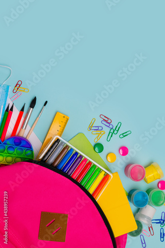 Back to school. Bright colorful school supplies and backpack for school or college on a blue background.Stationery for school children's studies. Greeting card or banner for sale. layout