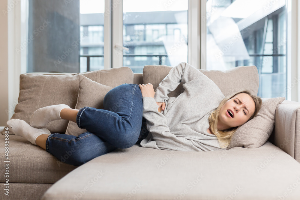 young woman sitting or lying on sofa or couch at home with severe abdominal pain. Female on bed holds her stomach with premenstrual, menstrual or poisoning. blonde girl suffers from abdominal cramps
young woman sitting or lying on sofa or couch at home with severe abdominal pain. Female on bed holds her stomach with premenstrual, menstrual or poisoning. blonde girl suffers from abdominal cramps
