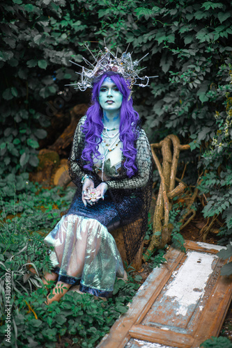 fabulous dark mermaid with blue skin in the forest close up