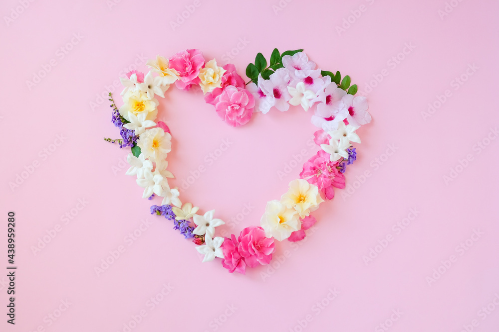 Beautiful heart shaped,Frame composition,various fresh flowers on pink background.Copy space.Valentines, mothers,women's day concept.Flat lay,top view.Template,design of wedding invitations,cards.