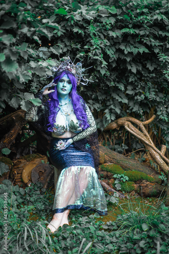 fabulous dark mermaid with blue skin in the forest close up