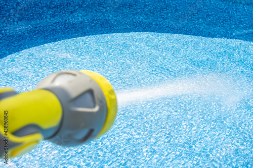 Close-up of filling the water into an empty swimming pool by garden hose