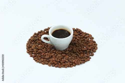 Coffee cup and beans on a white background. © Qwenergy