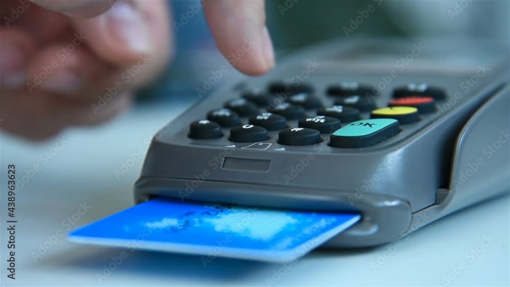 Hand Dials Pin Code On Pos Terminal With Blue Credit Card. Payment With Credit Card On Pos Terminal. Close Up Hand Dials Pin Code On Pos Terminal With Blue Credit Card. Payment With Credit Card On Pos Terminal. Close Up