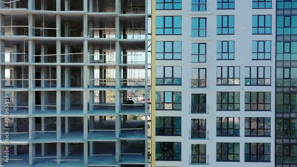 Aerial view of high residential apartment building under construction. Many windows on new apartment building facade under construction. Real estate development Aerial view of high residential apartment building under construction. Many windows on new apartment building facade under construction. Real estate development