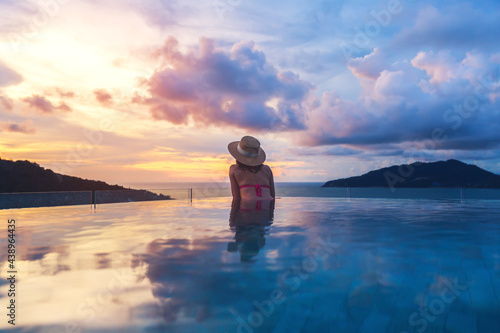 Asian travel bikini woman relax in infinity pool at resort phuket beach Thailand © Peera