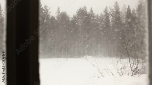 Rack focus shot of snow storm seen through a window
