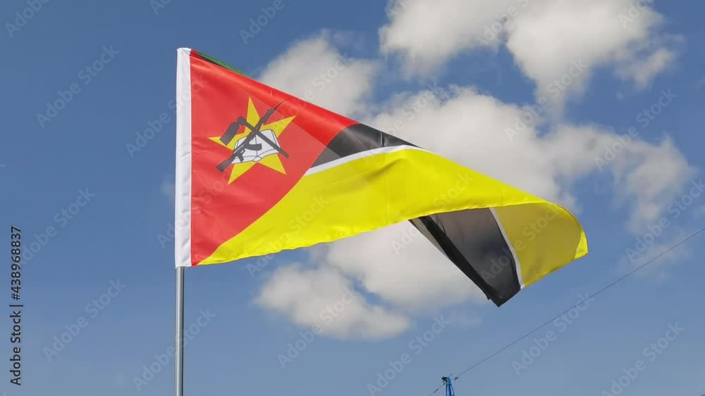 Mozambique. National country flag on blue sky background. Flying fabric symbol. Tourism or travel summer day. international patriotic emblem. Nobody. Horizontal video Mozambique. National country flag on blue sky background. Flying fabric symbol. Tourism or travel summer day. international patriotic emblem. Nobody. Horizontal video