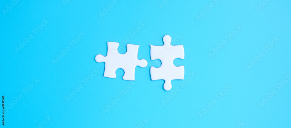 couple of white puzzle jigsaw pieces on blue background. Concept of solutions, mission, success, goals, cooperation, partnership, strategy and puzzle day couple of white puzzle jigsaw pieces on blue background. Concept of solutions, mission, success, goals, cooperation, partnership, strategy and puzzle day