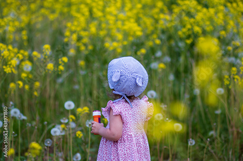 little girl in a field of dandelions