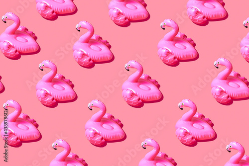 Inflatable pink flamingo pool toy pattern on pink background. Creative minimal summer concept