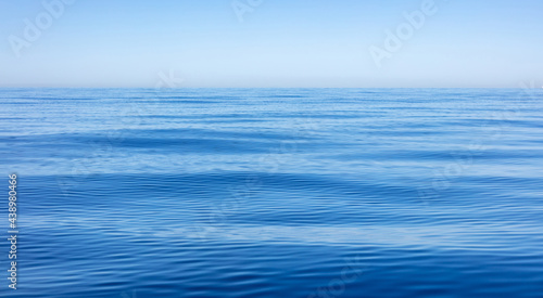 Sea water surface calm with small ripples. Still ocean, deep blue color background,