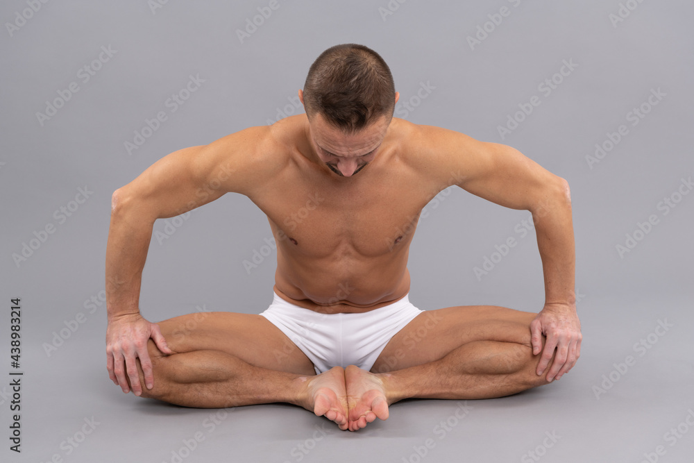 Yogi man do bound angle pose. Practicing thighs stretch. Yoga stretch. Butterfly Asana