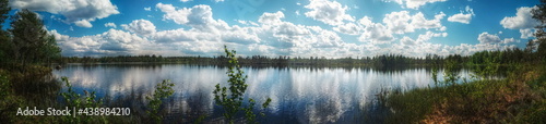 Panorama of small Swedish lake with heavy clouds and sunlight