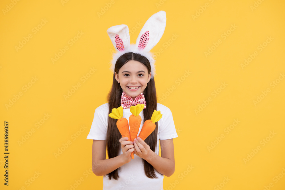 happy easter kid girl in bunny ears and bow tie hold carrot, happy easter