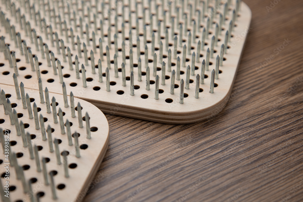 The Sadhu board is lying on the wooden floor. Yoga equipment. Lifestyle. Spiritual practice The Sadhu board is lying on the wooden floor. Yoga equipment. Lifestyle. Spiritual practice