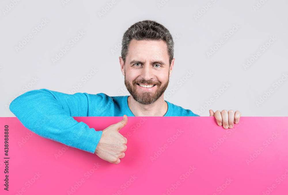happy man behind blank paper banner with copy space for job offer show thumb up, proposition. happy man behind blank paper banner with copy space for job offer show thumb up, proposition.