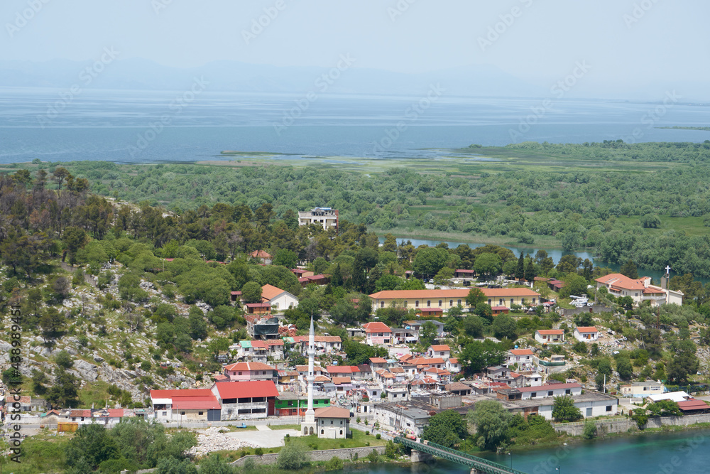 Aerial view of city Shkoder, mosque at river near big lake and castel hill