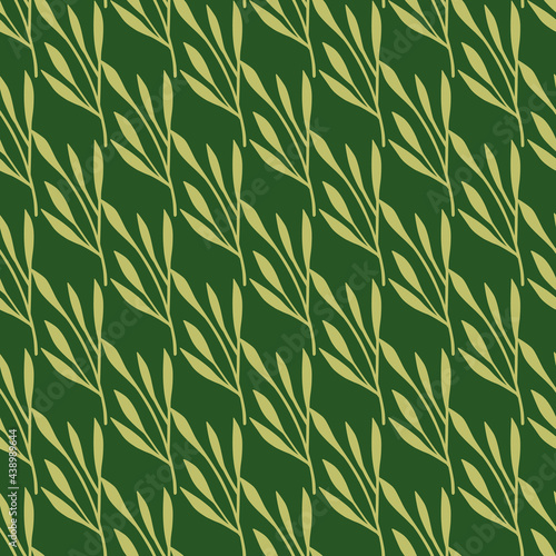 Fototapeta Naklejka Na Ścianę i Meble -  Creative seamless pattern with beige little leaves branches silhouettes. Green background. Doodle backdrop.