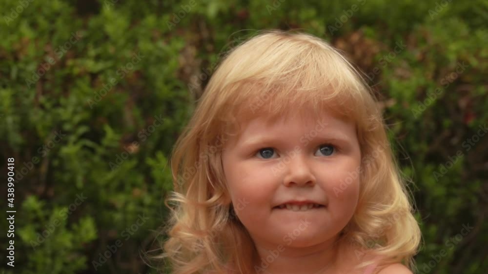 Portrait of a beautiful little blond girl smiling in a sunny park outdoors Portrait of a beautiful little blond girl smiling in a sunny park outdoors