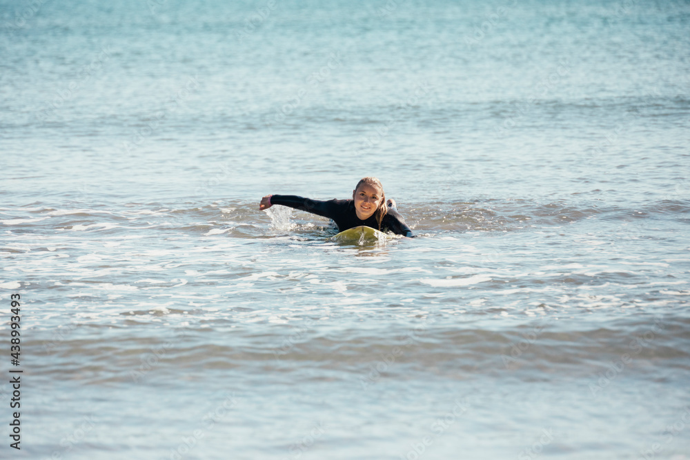 Girl swimming on a surfboard in the sea. 