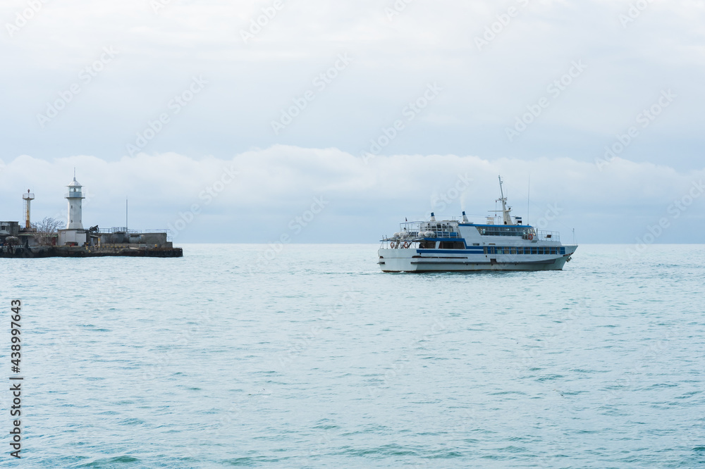 A pleasure ship with tourists leaves the port in the early spring morning