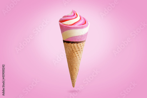 Pink and yellow ice cream in waffles cone on a pink background